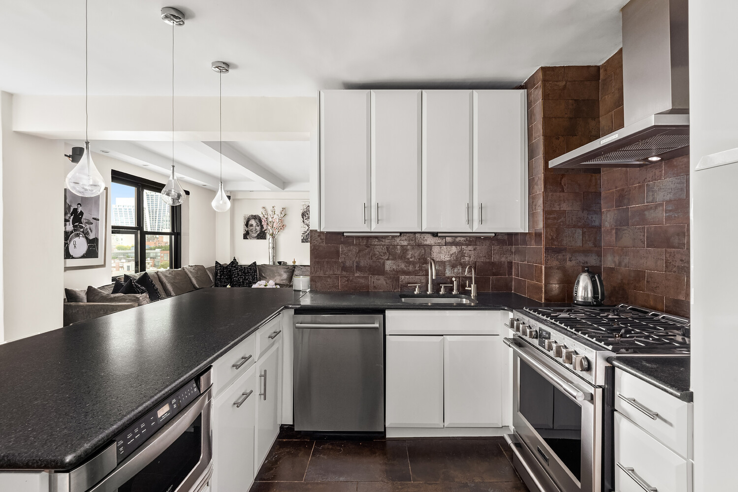 300 West 23rd Street, Unit 11M Manhattan, NY 10011 - Photo 5 of 9 a kitchen with stainless steel appliances granite countertop a sink a stove and cabinets
