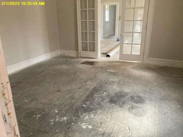 a view of a livingroom with a chandelier fan and windows