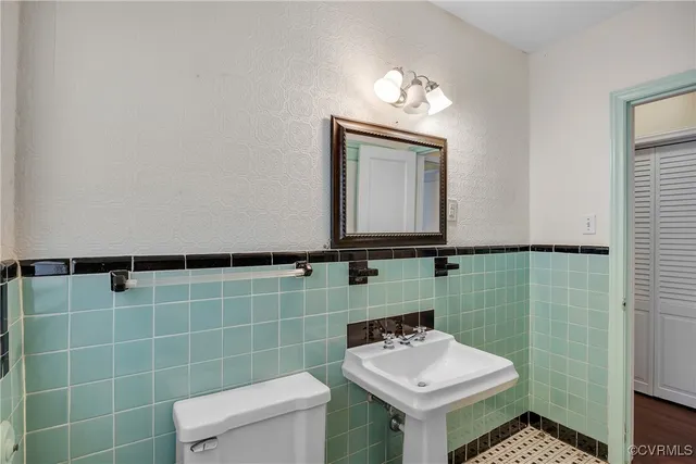 a bathroom with a toilet sink and mirror