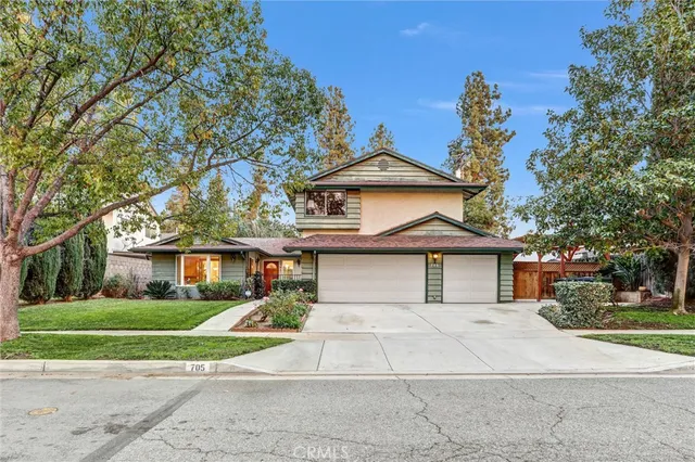 a front view of a house with a yard and potted plants