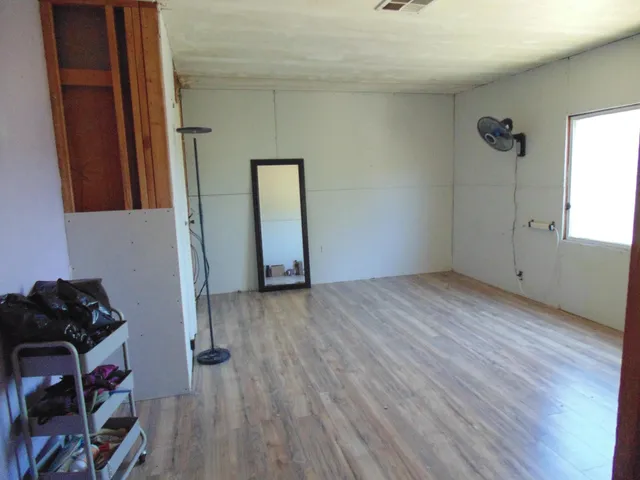 an empty room with wooden floor and closet