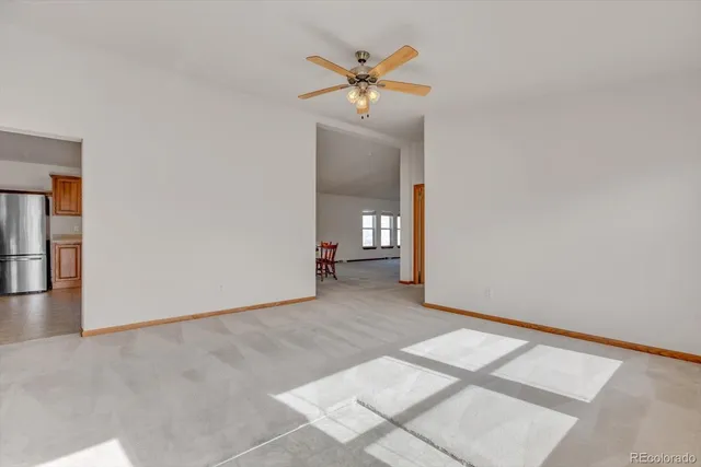 an empty room with a ceiling fan and a window