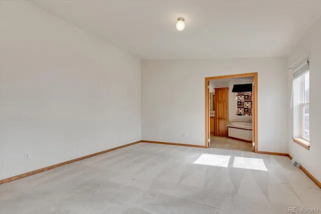 an empty room with windows and closet