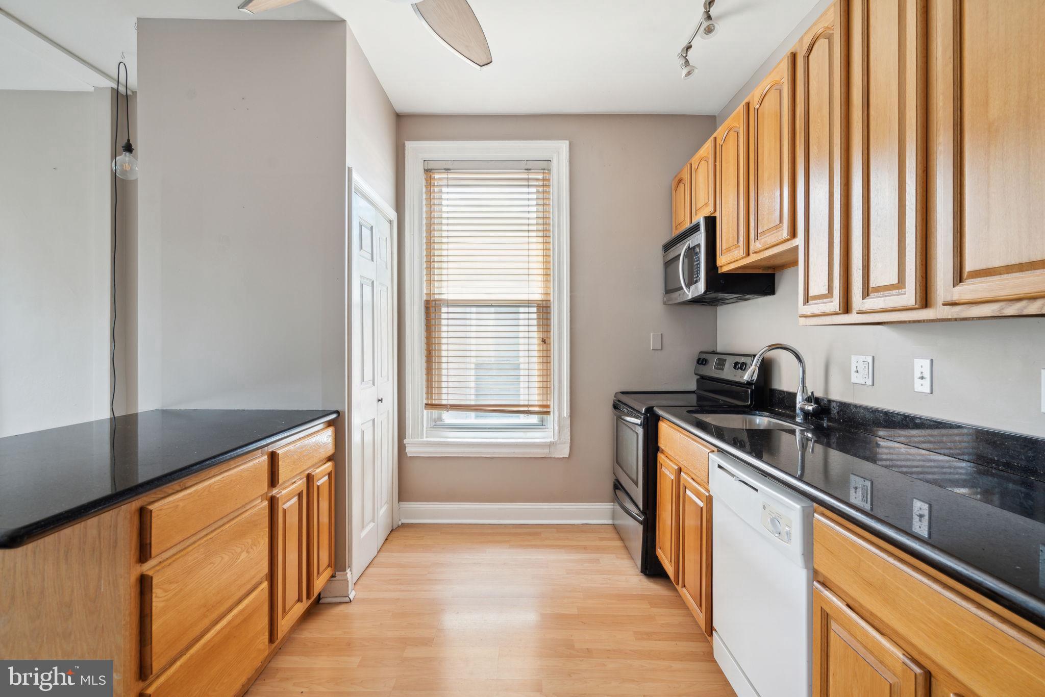 1936 North 7th Street, Unit 3 Philadelphia, PA 19122 - Photo 7 of 29 a kitchen with stainless steel appliances granite countertop a sink a stove and a refrigerator