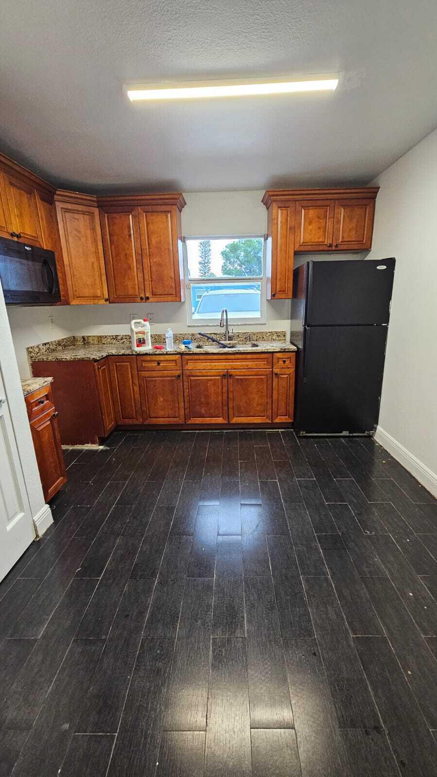 3391 Avenue South Riviera Beach, FL 33404 - Photo 8 of 16 a kitchen with wooden floors and kitchen