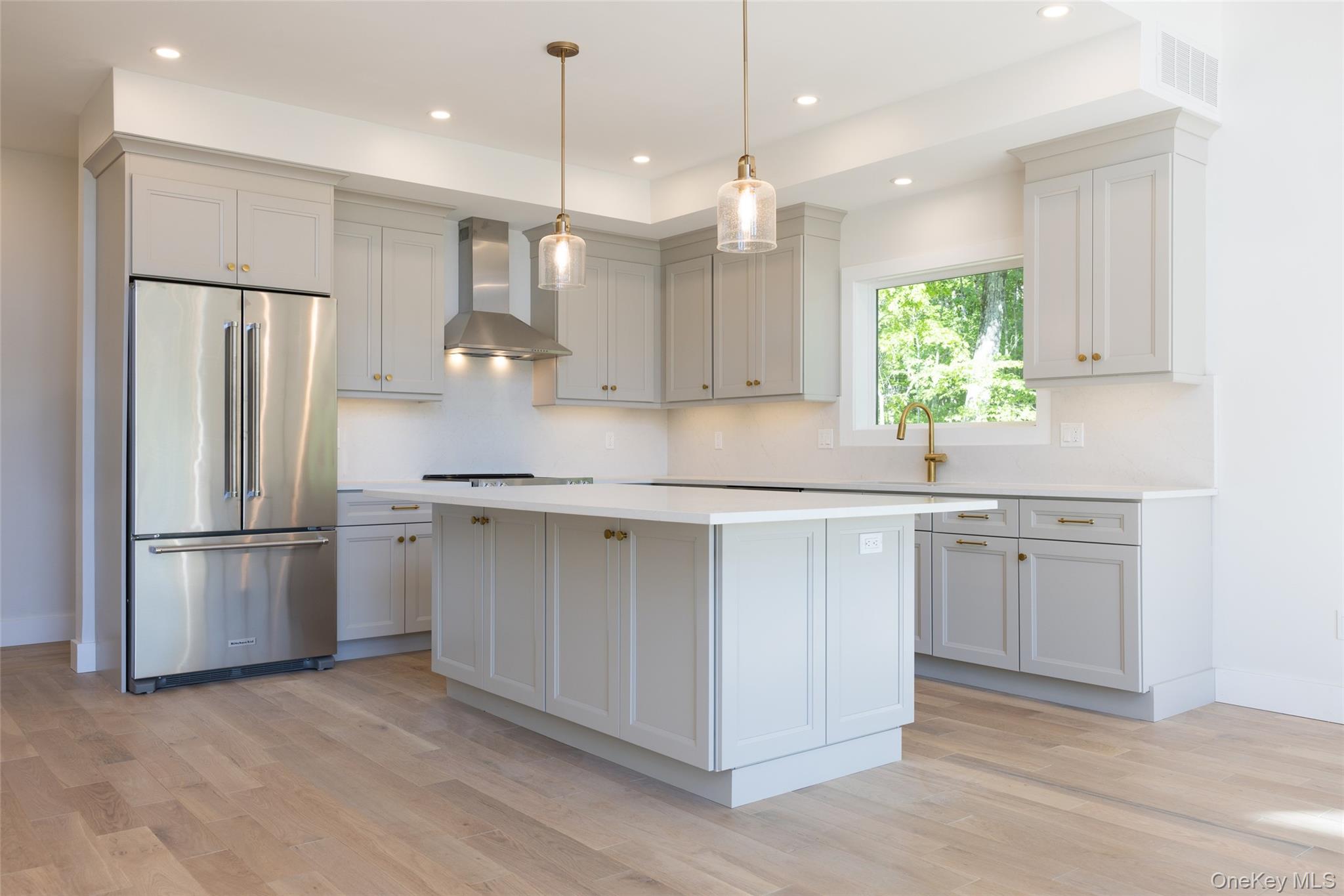 91 Lenni Lenape Road Narrowsburg, NY 12764 - Photo 5 of 25 Contemporary kitchen featuring light wood-finish flooring, light grey cabinetry, a central island, stainless steel appliances, and recessed lighting