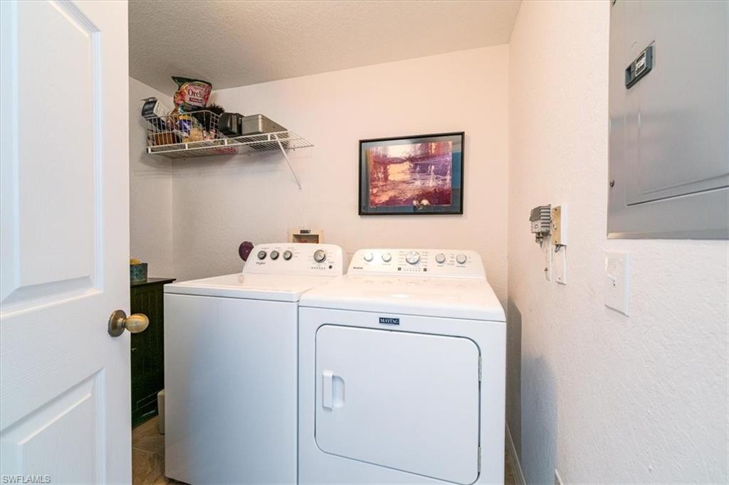 186 Gabriel Circle, Unit 3903 Naples, FL 34104 - Photo 20 of 42 Laundry area with electric panel, separate washer and dryer, and a textured wall