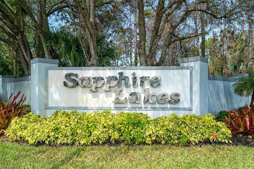 186 Gabriel Circle, Unit 3903 Naples, FL 34104 - Photo 2 of 42 Community sign with view of wooded area