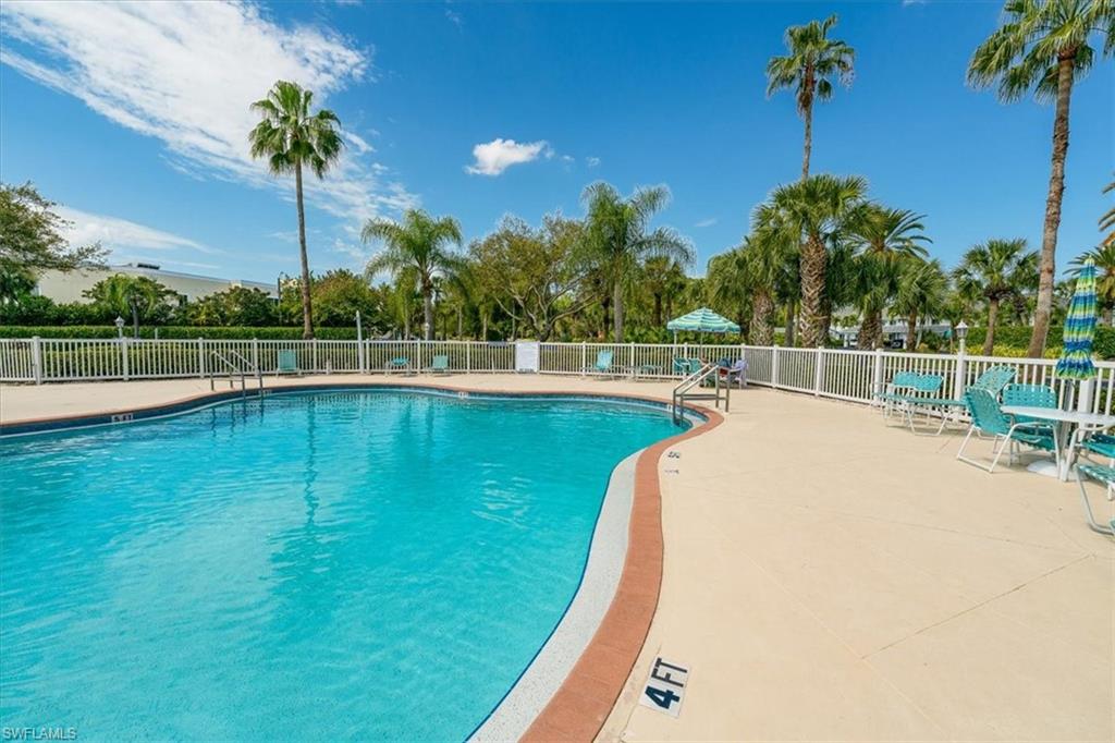 186 Gabriel Circle, Unit 3903 Naples, FL 34104 - Photo 28 of 42 Community pool with a patio area
