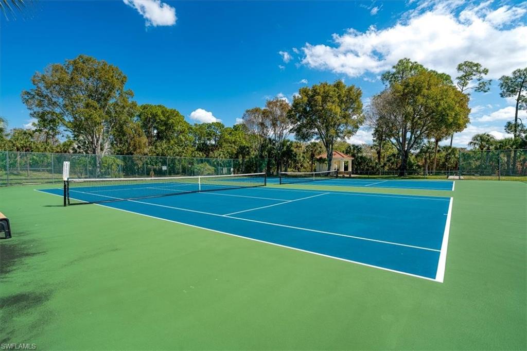 186 Gabriel Circle, Unit 3903 Naples, FL 34104 - Photo 33 of 42 View of tennis court with view of scattered trees