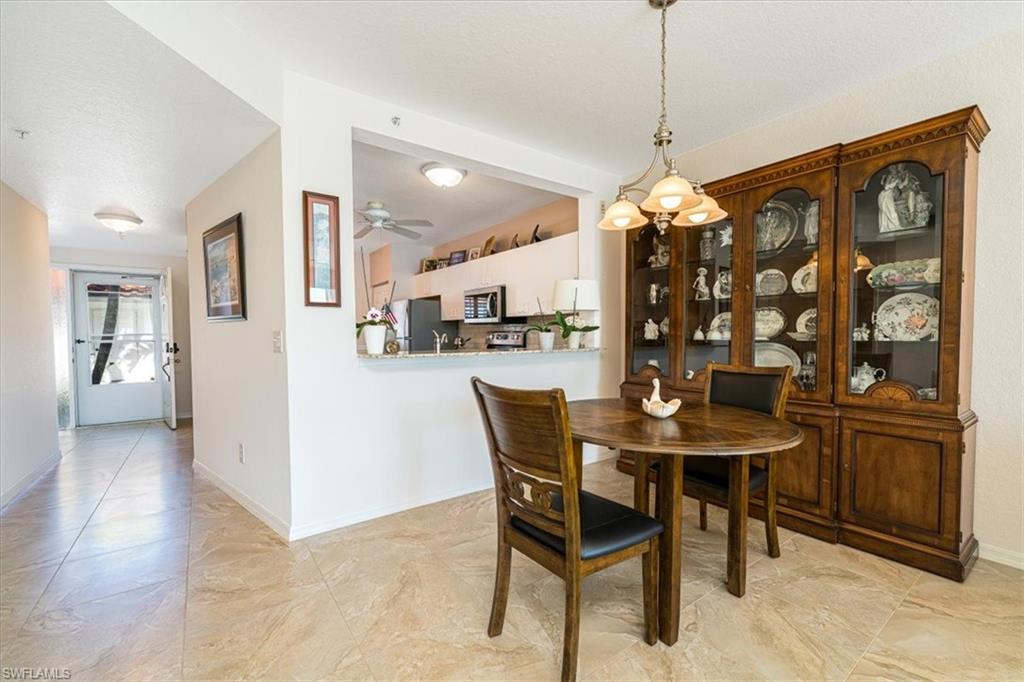 186 Gabriel Circle, Unit 3903 Naples, FL 34104 - Photo 6 of 42 Dining room with hanging lights and a ceiling fan