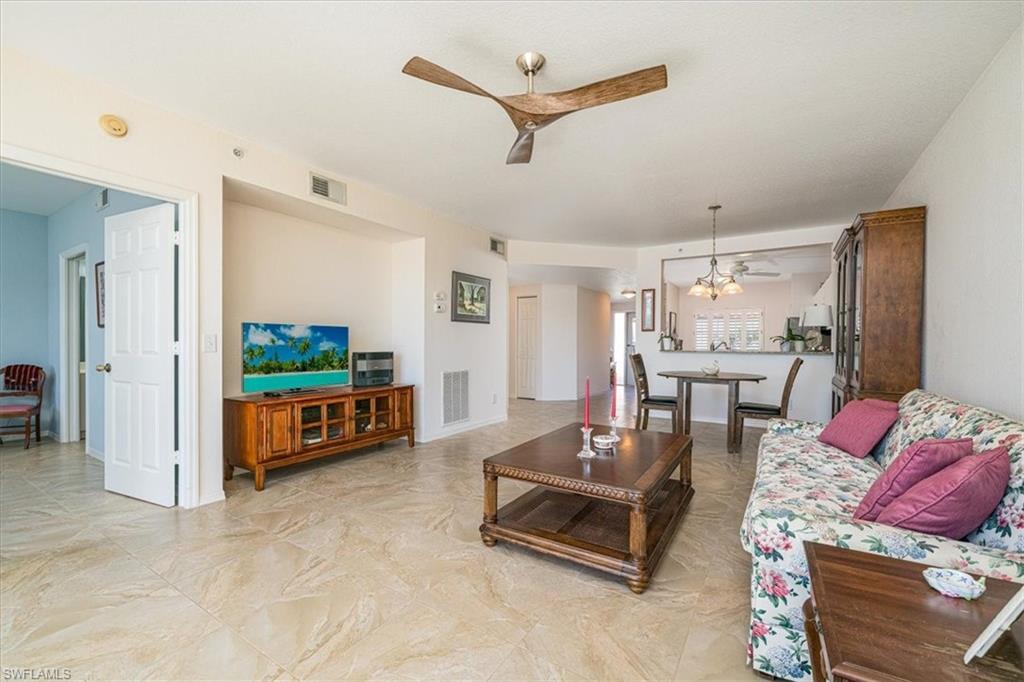 186 Gabriel Circle, Unit 3903 Naples, FL 34104 - Photo 7 of 42 Living area featuring ceiling fan and hanging lights