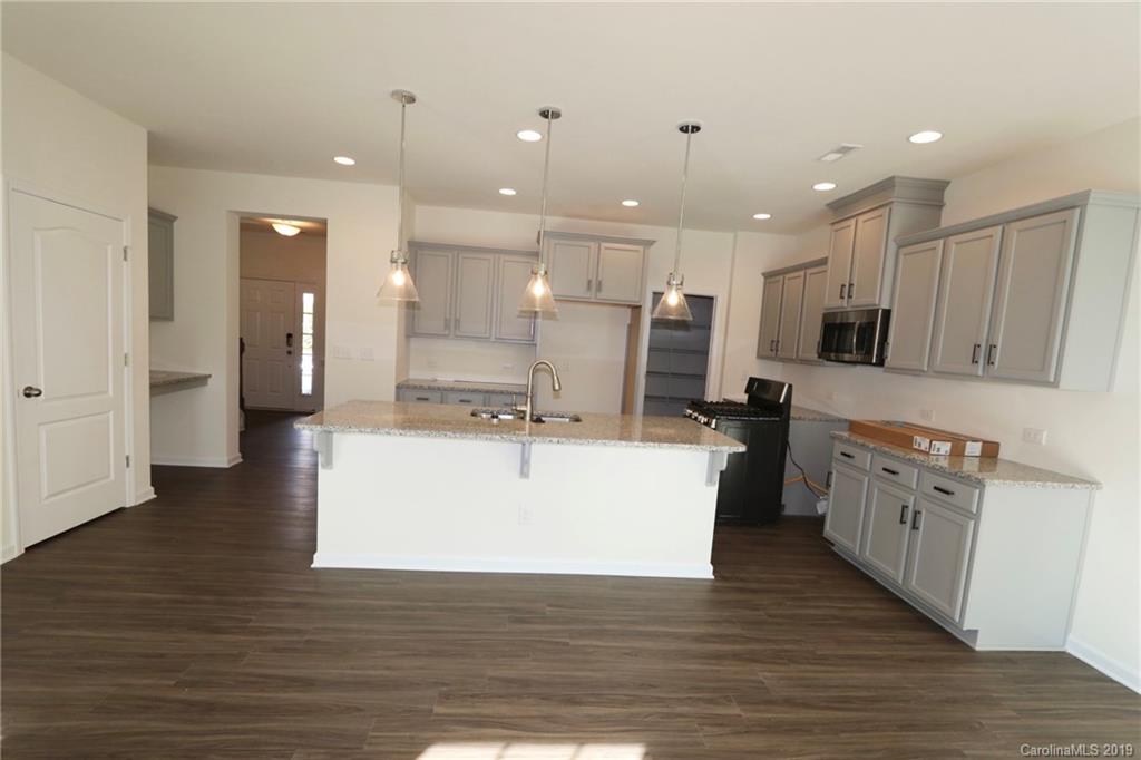 623 Amber Meadows Way, Unit 273 Tega Cay, SC 29708 - Photo 3 of 9 a large kitchen with stainless steel appliances kitchen island a large counter top and a wooden floors
