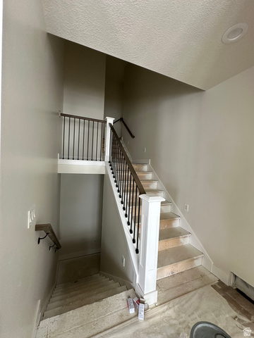143 South Chamberlain Street, Unit 327 Mapleton, UT 84664 - Photo 8 of 12 Stairs featuring a textured ceiling and baseboards