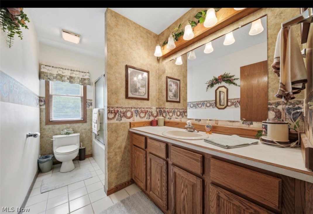 3556 Lake Road Conneaut, OH 44030 - Photo 30 of 39 Bathroom featuring a wood-finish vanity with a large counter, an integrated sink, and an expansive wall mirror with overhead lighting
