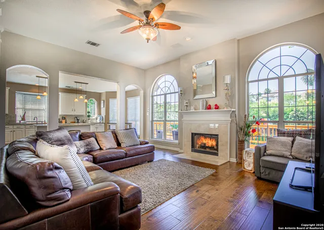 a living room with furniture a fireplace and a large window