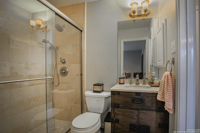 a bathroom with a sink vanity mirror and toilet