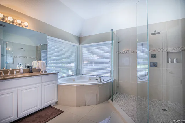 a large bathroom with a granite countertop sink a toilet a mirror and shower