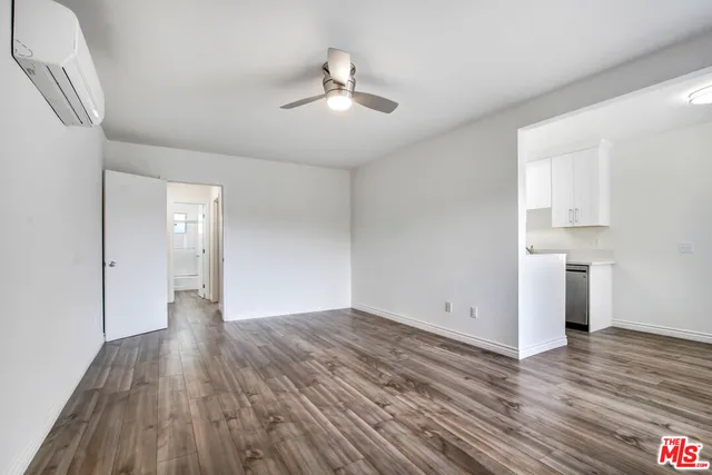 a view of empty room with wooden floor and window