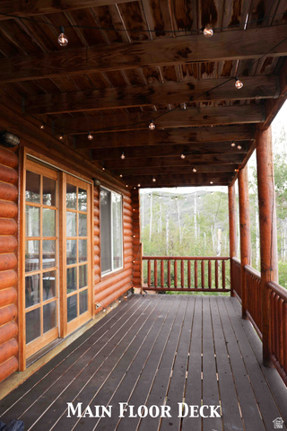 15253 Mill Road, Unit 62 Huntsville, UT 84317 - Photo 40 of 48 Covered outdoor deck with dark wood-finish flooring, log siding exterior, and wood-framed French doors