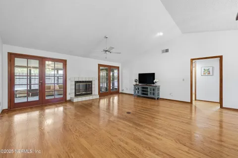 a view of a livingroom with a kitchen wooden floor and a ceiling fan