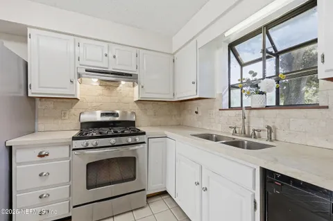 a kitchen with stainless steel appliances granite countertop a stove a refrigerator and a cabinets