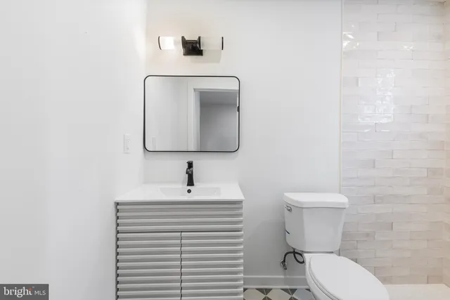 a bathroom with a toilet a sink and mirror