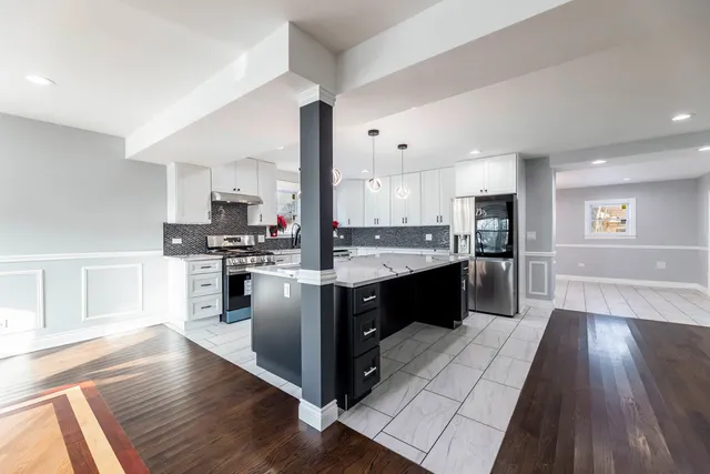 a kitchen with stainless steel appliances granite countertop a sink a stove and a refrigerator