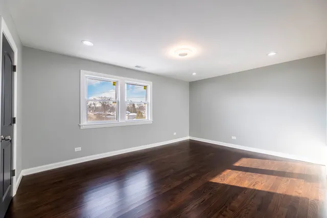 a bathroom with a toilet a sink a vanity and a window