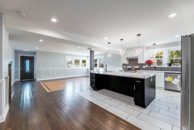 a large kitchen with a center island and wooden floor
