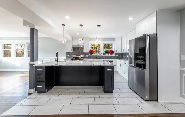 a kitchen with granite countertop a sink a counter top space stainless steel appliances and cabinets