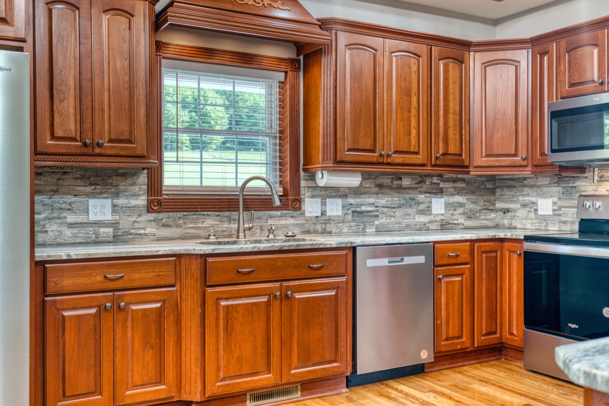 315 Blue And Gray Park Road Elkton, KY 42220 - Photo 34 of 66 a kitchen with granite countertop wooden cabinets a sink and dishwasher