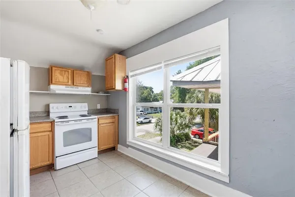 a kitchen with a stove a refrigerator and a window