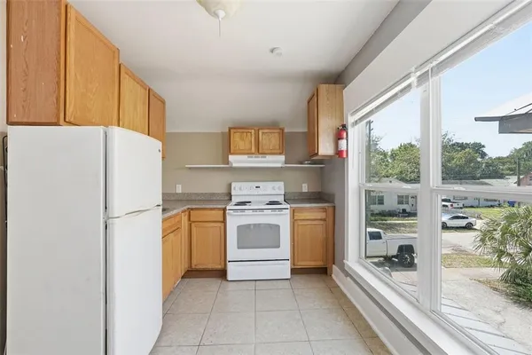 a kitchen with a refrigerator a stove top oven a sink and a large window