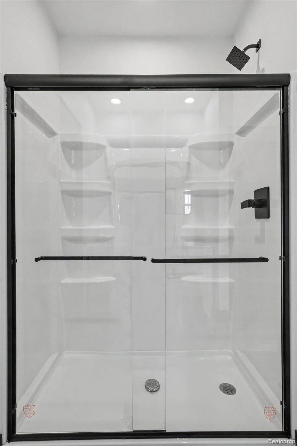 12425 Miller Road Lennon, MI 48449 - Photo 21 of 26 Shower enclosure featuring sliding glass doors with matte black hardware