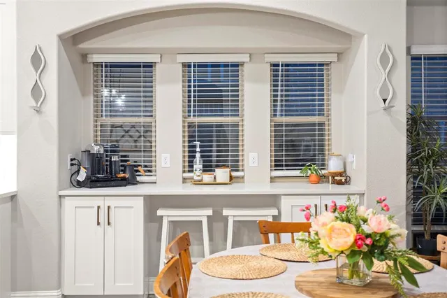 a kitchen with stainless steel appliances kitchen island a table chairs microwave and refrigerator