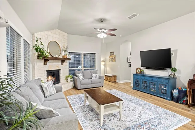 a living room with furniture a fireplace and a chandelier