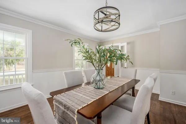 a dining room with furniture window and wooden floor