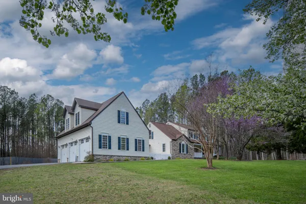 an aerial view of a house with outdoor space and trees all around