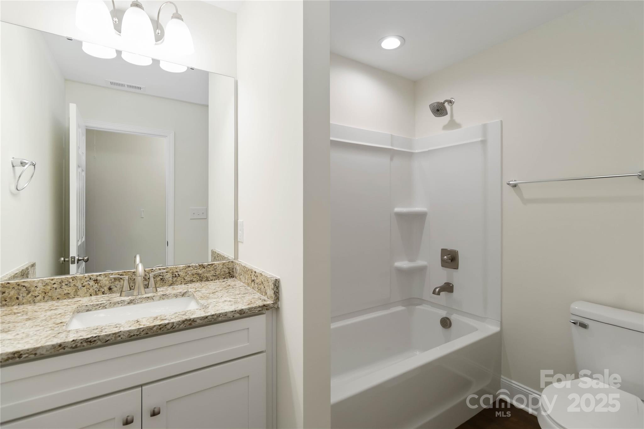 1018 Heath Helms Road Monroe, NC 28110 - Photo 19 of 38 a bathroom with a granite countertop sink a toilet and bathtub