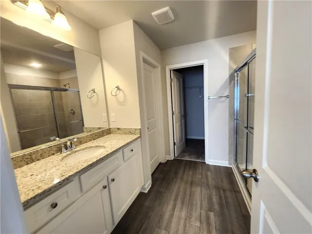a bathroom with a granite countertop double vanity sink and mirror