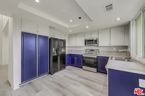 a kitchen with granite countertop stainless steel appliances and wooden cabinets