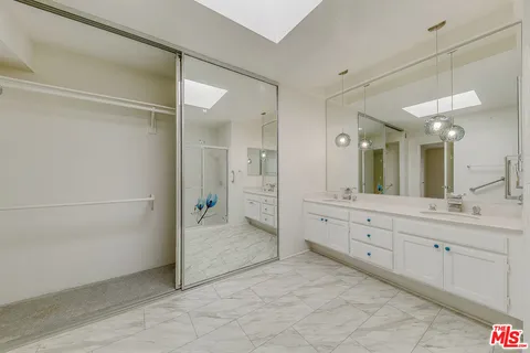 a spacious bathroom with a granite countertop sink mirror and a