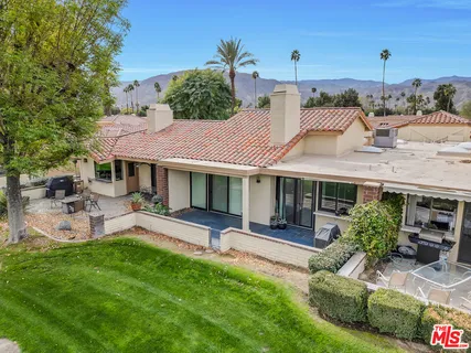 a front view of a house with a garden and sitting area