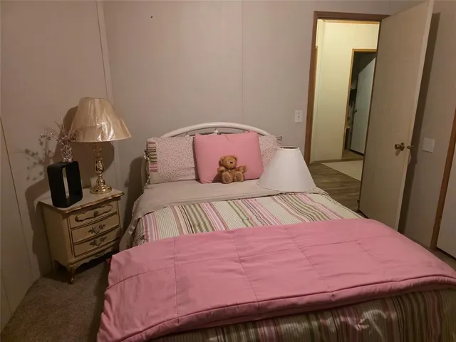 a bedroom with a bed a dresser and a mirror