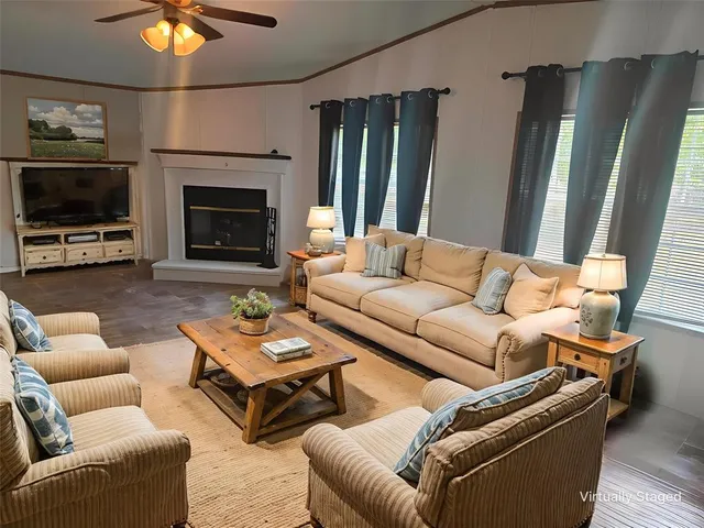 a living room with furniture a flat screen tv and a fireplace