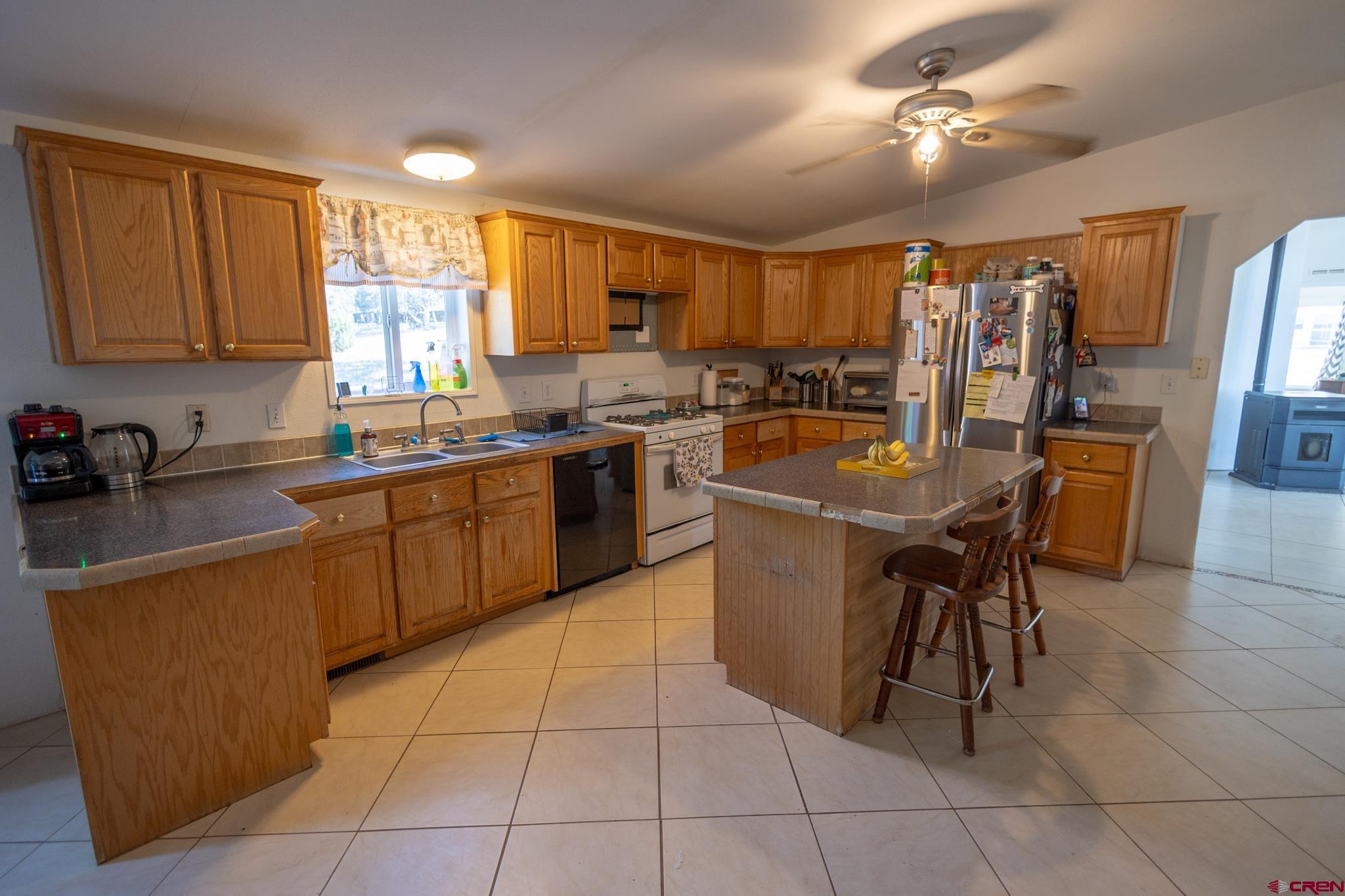 13569 3100th Road Hotchkiss, CO 81419 - Photo 14 of 31 a kitchen with a sink a counter top space appliances and cabinets