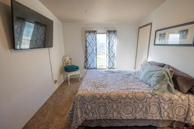 a bedroom with a bed mirror and window