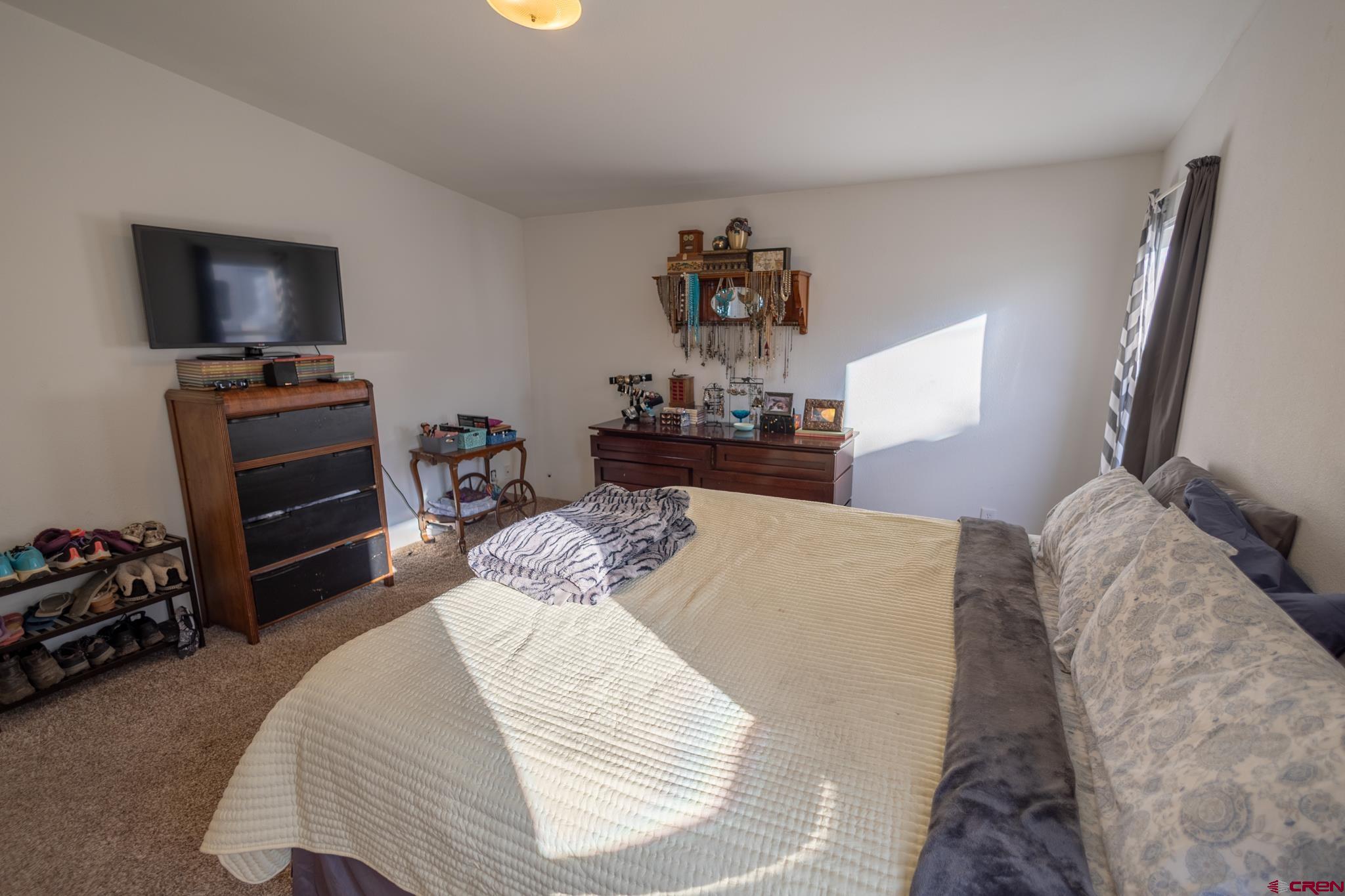 13569 3100th Road Hotchkiss, CO 81419 - Photo 21 of 31 a bedroom with a bed and a flat tv screen on dresser