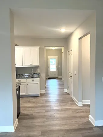 a kitchen with a refrigerator and white cabinets